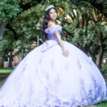Houston Quinceañera photographer capturing a quinceañera in a blue XV ball gown in a park